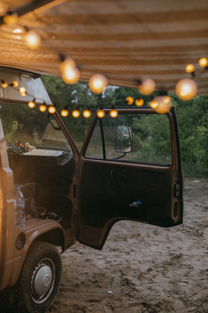 An inviting camper van scene with string lights at a campsite.